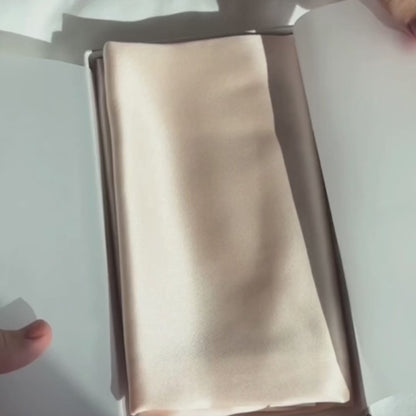 Uitpakken van een zijden kussensloop in licht roze